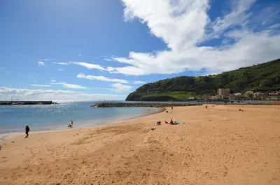a group of people on a beach near the water at Ocean View Machico in Machico