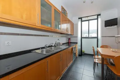a kitchen with a sink and a table with a dining room at Ocean View Machico in Machico