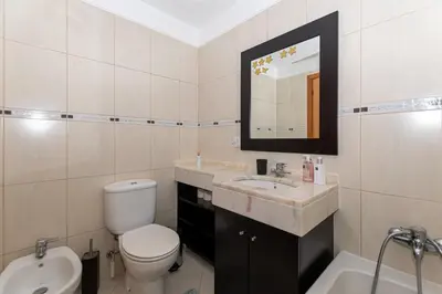 a bathroom with a toilet and a sink and a mirror at Ocean View Machico in Machico