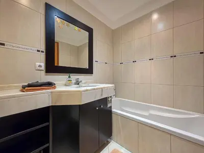 a bathroom with a sink and a tub and a mirror at Ocean View Machico in Machico