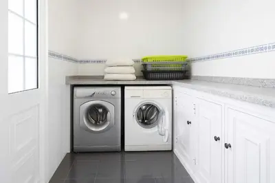 a white laundry room with a washer and dryer at Armando House Ocean View in Gaula