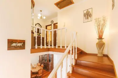 a staircase in a home with wooden floors and white walls at Armando House Ocean View in Gaula