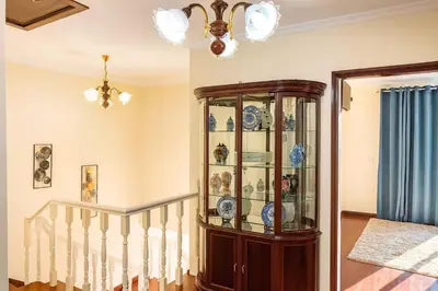 a china cabinet in a room with a staircase at Armando House Ocean View in Gaula