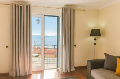 a living room with a couch and a sliding glass door at Armando House Ocean View in Gaula