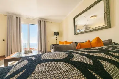 a bedroom with a large bed and a mirror at Armando House Ocean View in Gaula