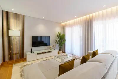 a living room with a white couch and a tv at Mar e Sol Chic & Modern City Apartment in Funchal