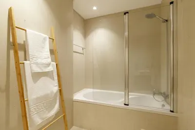 a bathroom with a shower and a bath tub with a glass door at Mar e Sol Chic & Modern City Apartment in Funchal