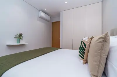 a bedroom with a white bed with pillows at Mar e Sol Chic & Modern City Apartment in Funchal