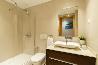 a bathroom with a sink and a toilet and a shower at Mar e Sol Chic & Modern City Apartment in Funchal