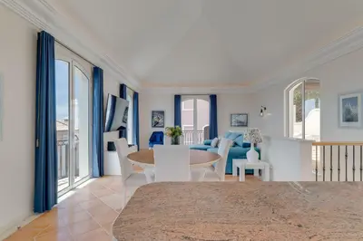 a living room with a table and chairs at Villa Sol Palheiro Village by Holiday Rental Madeira in Funchal
