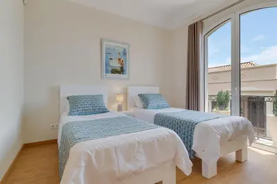 a large swimming pool with chairs and a building at Villa Sol Palheiro Village by Holiday Rental Madeira in Funchal