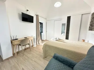 a bedroom with a bed and a desk and a tv at Mocha Studio in Machico
