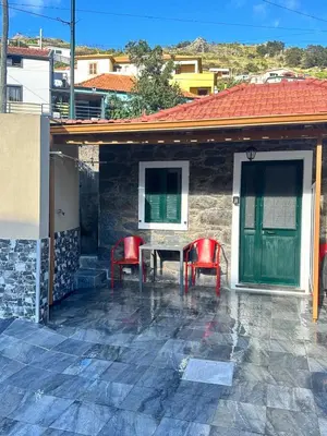 a patio with two red chairs and a table at Mocha Studio in Machico