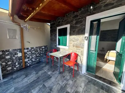 a table and chairs in a room with a stone wall at Mocha Studio in Machico