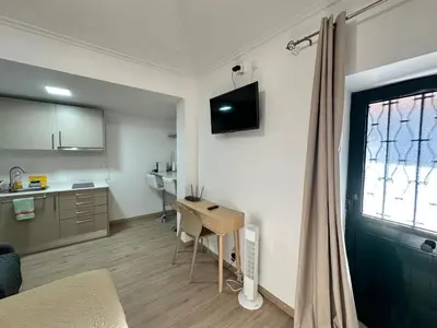 a room with a desk and a kitchen with a window at Mocha Studio in Machico