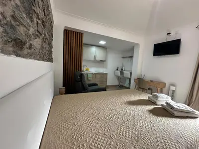 a bedroom with a bed with a chair and a desk at Mocha Studio in Machico