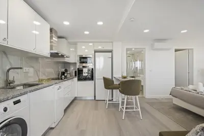 a bedroom with a large bed and a kitchen at Camacho Studios by Homie in Funchal
