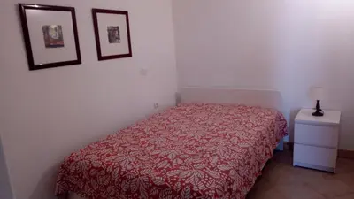 a bedroom with a bed with a red blanket at Sea View Apartment in Lagos