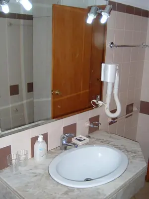 a bathroom with a sink and a large mirror at Sea View Apartment in Lagos