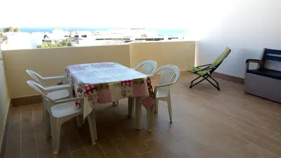 a table and chairs in a room with a view at Sea View Apartment in Lagos
