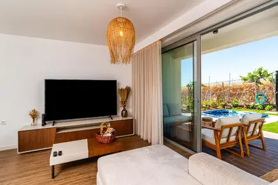 a living room with a television and a table with chairs at Star Lit Jacuzzi Apartment in Câmara de Lobos