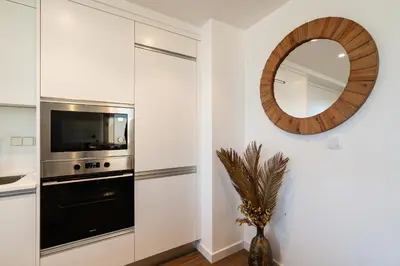 a kitchen with a microwave and a mirror on the wall at Star Lit Jacuzzi Apartment in Câmara de Lobos
