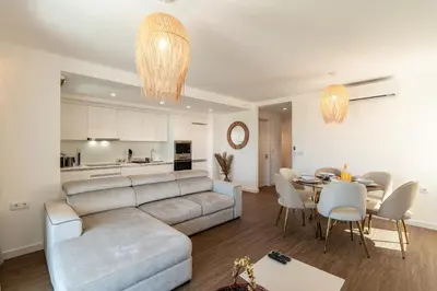 a living room and dining room with a couch and a table at Star Lit Jacuzzi Apartment in Câmara de Lobos