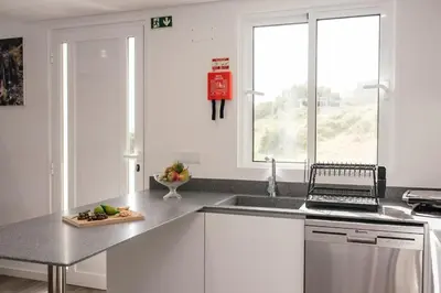 a kitchen with a sink and a laptop on a counter at Casa Piquita in Estreito da Calheta