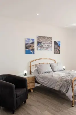 a bedroom with a bed and a chair at Casa Piquita in Estreito da Calheta