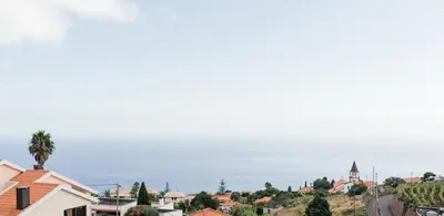 a view of a town with the ocean in the background at Casa Piquita in Estreito da Calheta