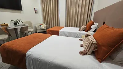 a hotel room with two beds and a table at Apartamento moderno no Funchal - Papaia by Tropical Solutions in Funchal