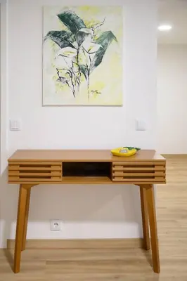 a wooden desk in a room with a painting on the wall at Montana by Mth in Funchal