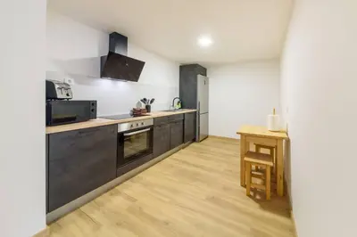 a kitchen with black appliances and a wooden floor at Montana by Mth in Funchal