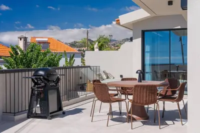 a patio with a table and chairs and a grill at Villa Mangoni - Brand New Luxury Villa in Funchal