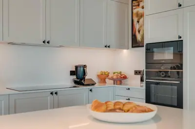 a white kitchen with a bowl of bread on a counter at Villa Mangoni - Brand New Luxury Villa in Funchal
