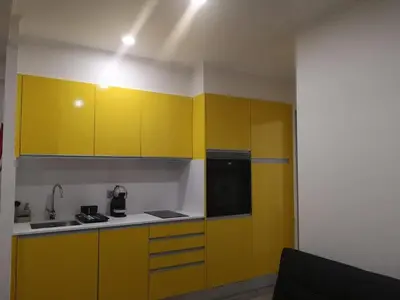 a kitchen with yellow cabinets and a black refrigerator at Apartamento moderno no Funchal - Araçá Apartment by Tropical Solutions in Funchal