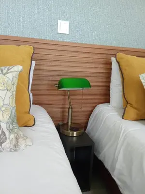 a green lamp sitting on a table between two beds at Apartamento moderno no Funchal - Araçá Apartment by Tropical Solutions in Funchal