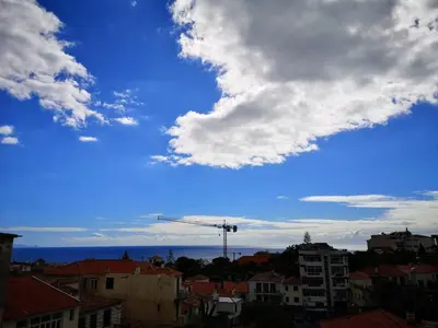 a view of a city with a crane in the sky at Apartamento moderno no Funchal - Araçá Apartment by Tropical Solutions in Funchal