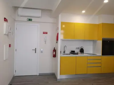a kitchen with yellow cabinets and a fire extinguisher at Apartamento moderno no Funchal - Araçá Apartment by Tropical Solutions in Funchal