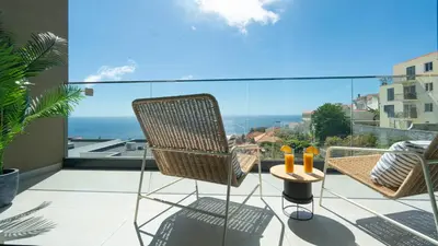 a balcony with a chair and a view of the ocean at Villa Nero by LovelyStay in Funchal