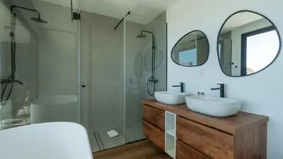 a bathroom with two sinks and a shower and mirrors at Villa Nero by LovelyStay in Funchal