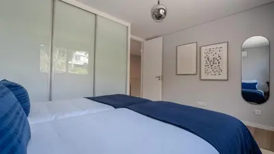 a bedroom with a white bed with blue sheets at Villa Nero by LovelyStay in Funchal