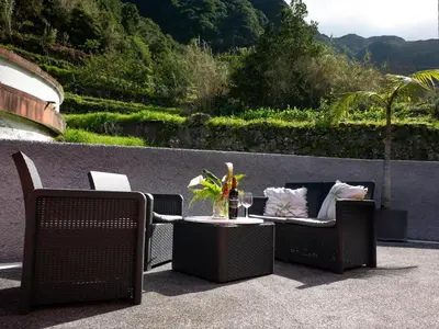 a patio with two chairs and a table with a drink at Casa Do Senhor, By OP in São Vicente