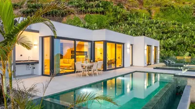 a villa with a swimming pool and a house at Eco Fajã Villas in Arco da Calheta
