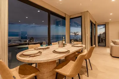 a dining room with a wooden table and chairs at Eco Fajã Villas in Arco da Calheta