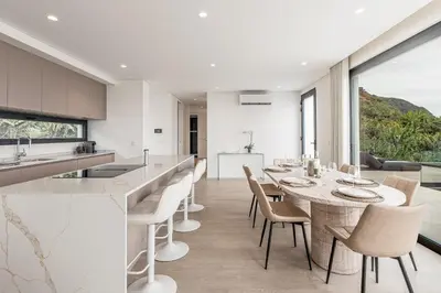 a kitchen and dining room with a table and chairs at Eco Fajã Villas in Arco da Calheta