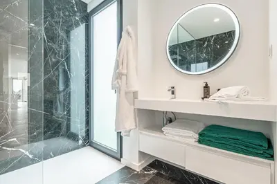 a bathroom with a shower and a mirror at Eco Fajã Villas in Arco da Calheta