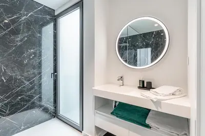 a bathroom with a shower and a sink with a mirror at Eco Fajã Villas in Arco da Calheta