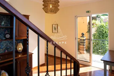 a staircase with the escape logo on the wall at Casa Lucas by Escape to Madeira in Arco da Calheta