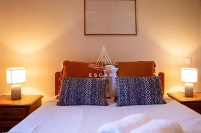 a bedroom with a bed with two lamps on it at Casa Lucas by Escape to Madeira in Arco da Calheta